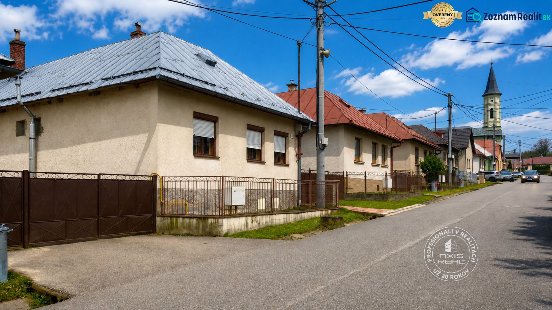 Rodinný dom Šambron, okr. Stará Ľubovňa - Rodinné domy na ulici v Šambrone s kostolom v pozadí pod modrou oblohou.