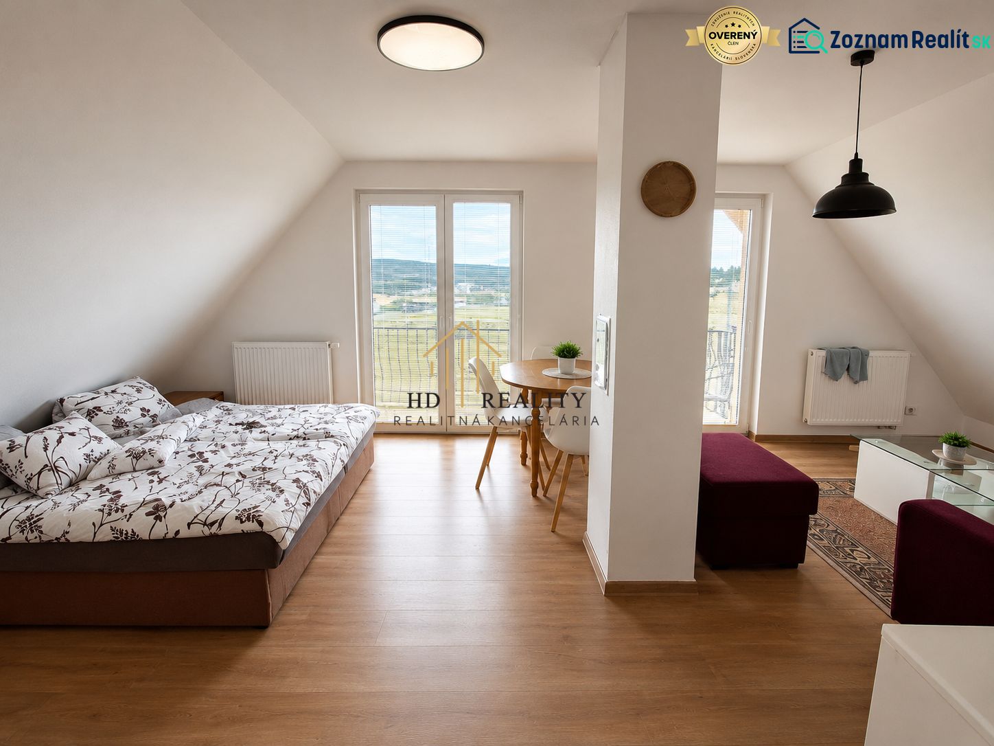 Prenájom, Apartmán v meste Krupina - Svetlá izba s podlahou s dreveným dekorom, sedačkou a jedálenským stolom v 2-izbovom byte.