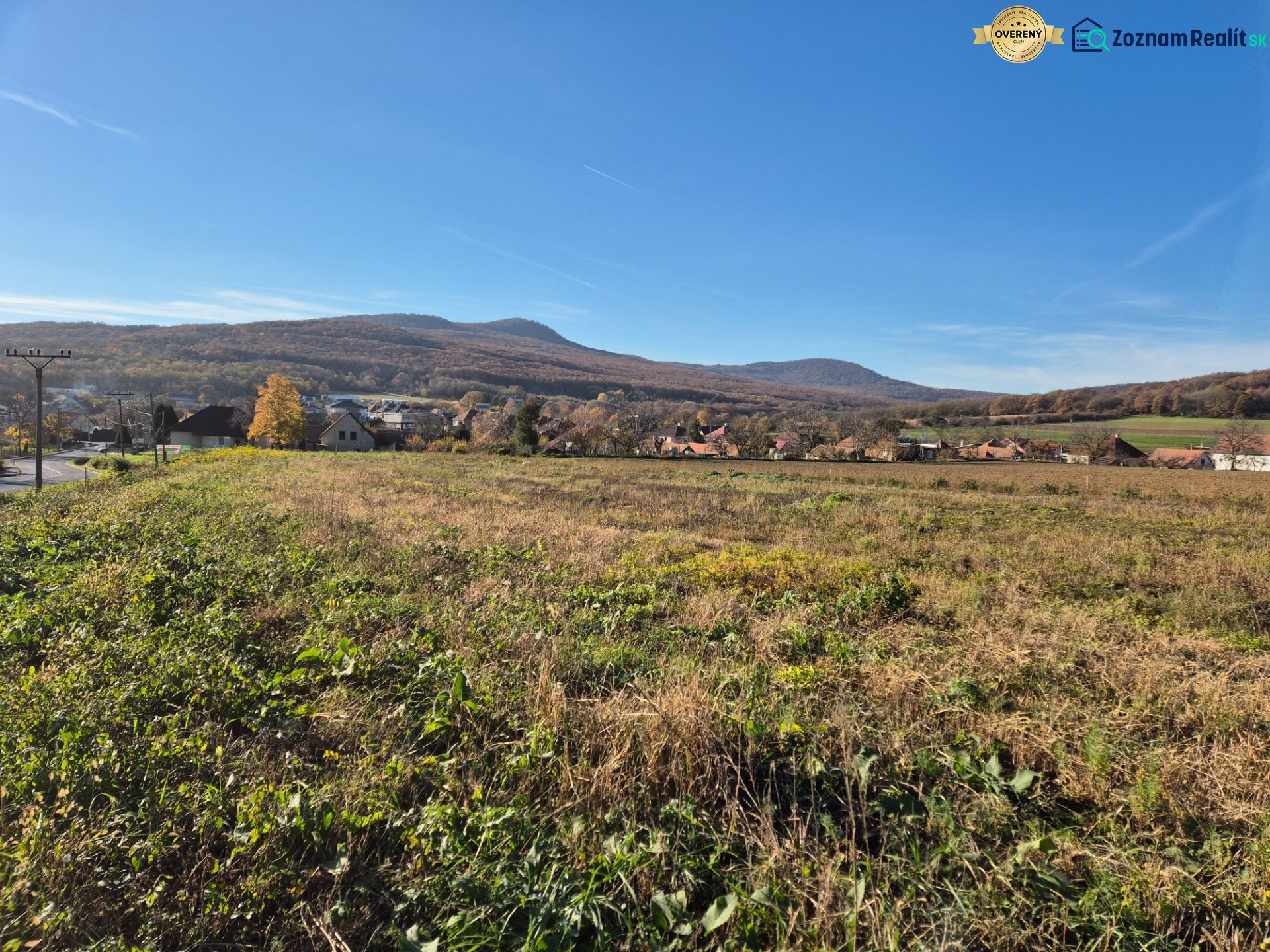 VELČICE - Stavebný pozemok, od 650 m2, okr. Zlaté Moravce - Výhľad na Pozemky - bývanie vo Velčiciach s kopcovitou krajinou v pozadí.