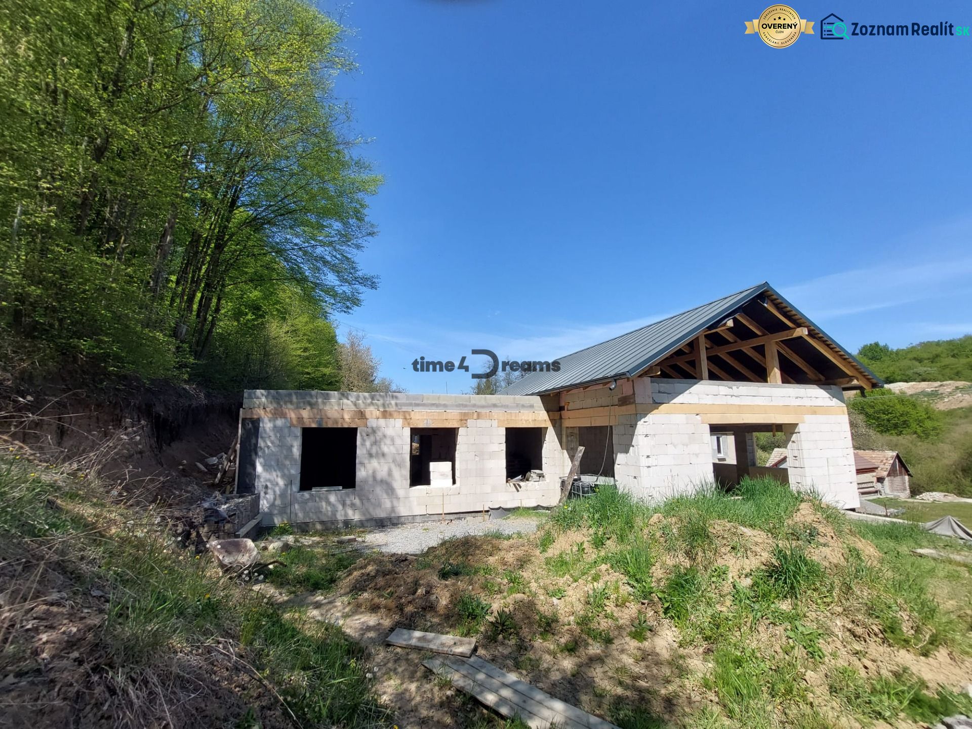 NA PREDAJ rozostavaný 5-izbový rodinný dom   - Stavba rodinného domu vo Zvolene, obklopená lesom a prírodou, pod modrou oblohou.