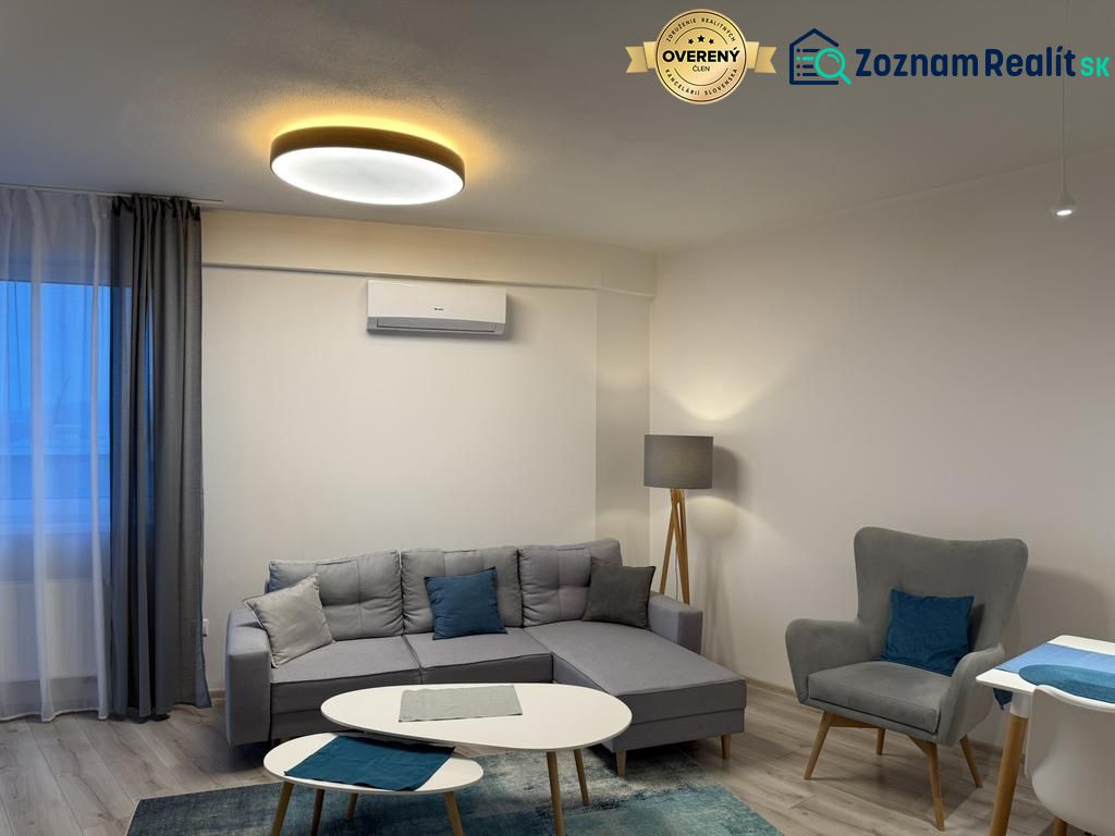 Nové skolaudované byty, apartmány a obch.priestory vo Vajnoroch. - Obývacia izba s pohovkou, kreslom a stolíkom v 2-izbovom byte s dekorom podlahy.