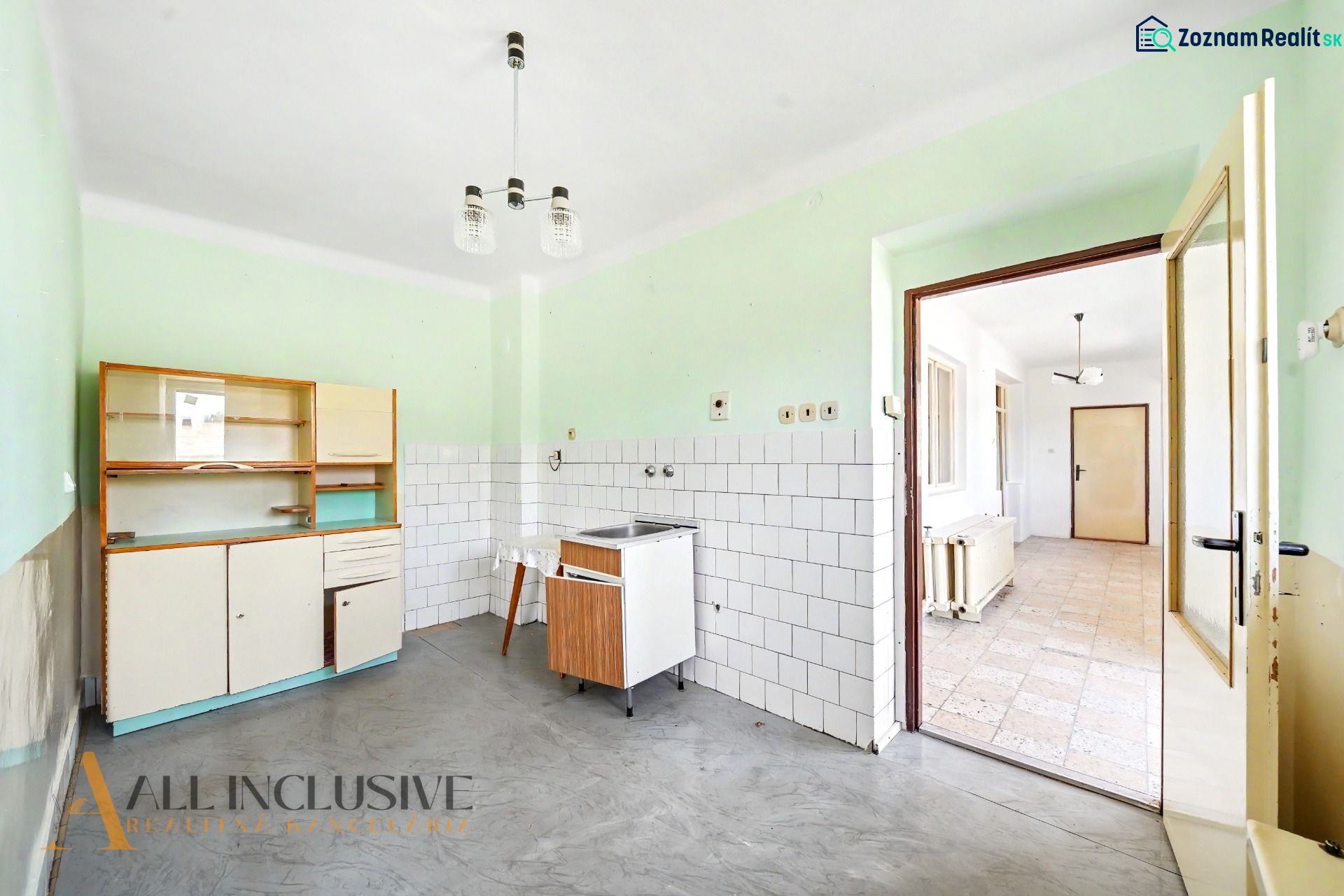 Na prenájom 5-izb. rod. dom s garážou, Vydrany - Kuchyňa v rodinnom dome s jednoduchou kuchynskou linkou, bielymi kachličkami a sivou podlahou.