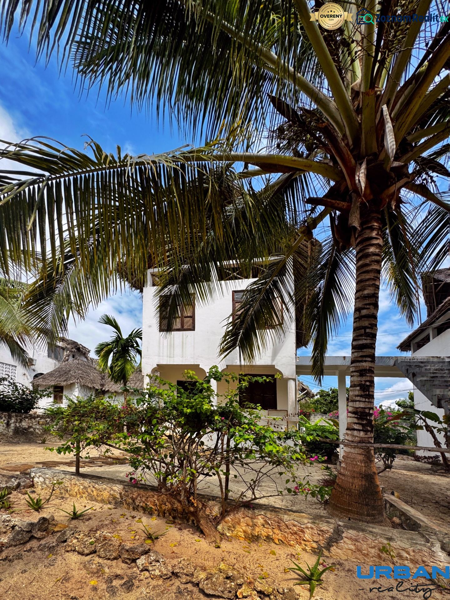SAMOSTATNE STOJACA VILA MAPUMZIKO S 2 IZBAMI NA ZANZIBARE  - Rodinný dom v Pwani Mchangani obklopený palmami a kvetmi na kamennej terase.