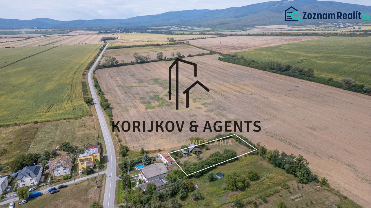 PREDAJ, Stavebný pozemok Sečovce - časť Albinov, intravilan  - Krajina v Sečovciach s rozľahlými pozemkami pre bývanie, obklopená poľami a cestou.