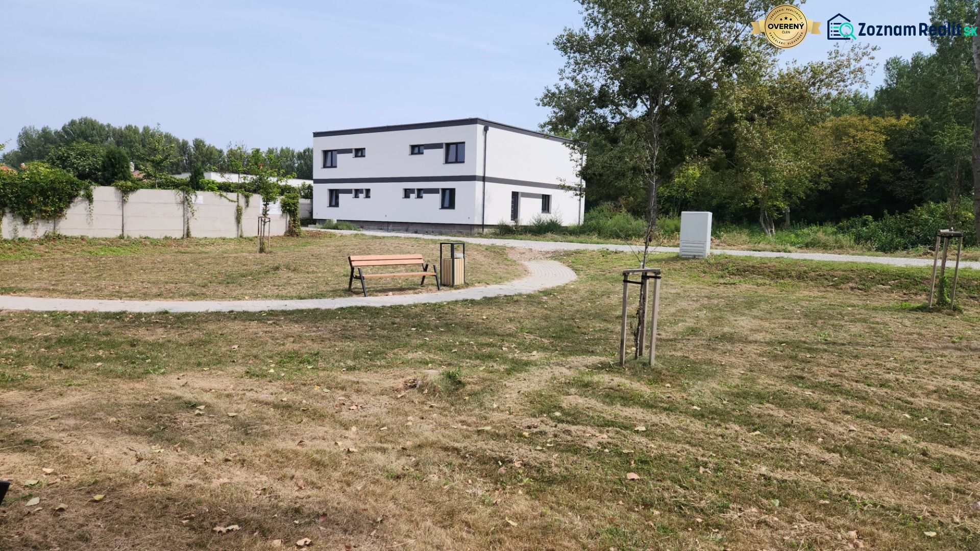 I Predaj 5-i mezonetu s vlastným pozemkom - Park s lavičkou a chodníkom, v pozadí budova v Dunajskom Klátove, 5 a viac izbový byt.