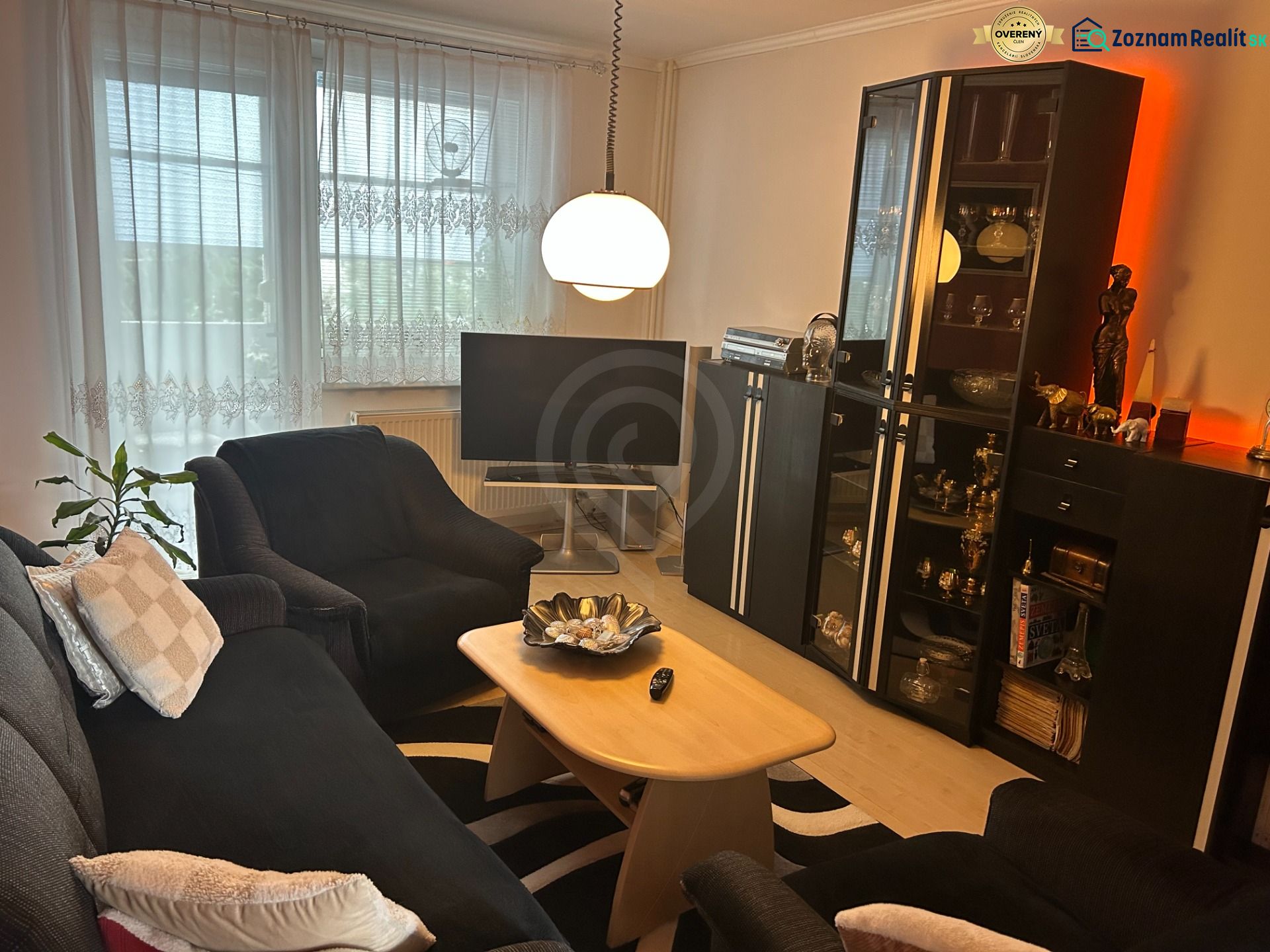 NA PREDAJ PRIESTRANNÝ 3-IZBOVÝ BYT | 67 m² | LODŽIA | 4. POSCHODIE - Obývacia izba v 3-izbovom byte s pohodlným posedením a stojatou lampou.