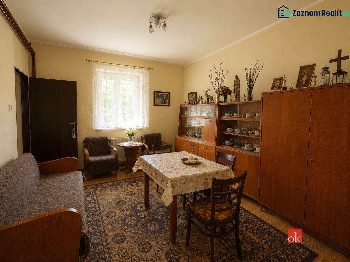 NA PREDAJ - Rodinný dom - Banská Bystrica - CENTRUM - Obývacia izba s dreveným nábytkom, podlahou s dreveným dekorom, kobercom a dekoračnými predmetmi.