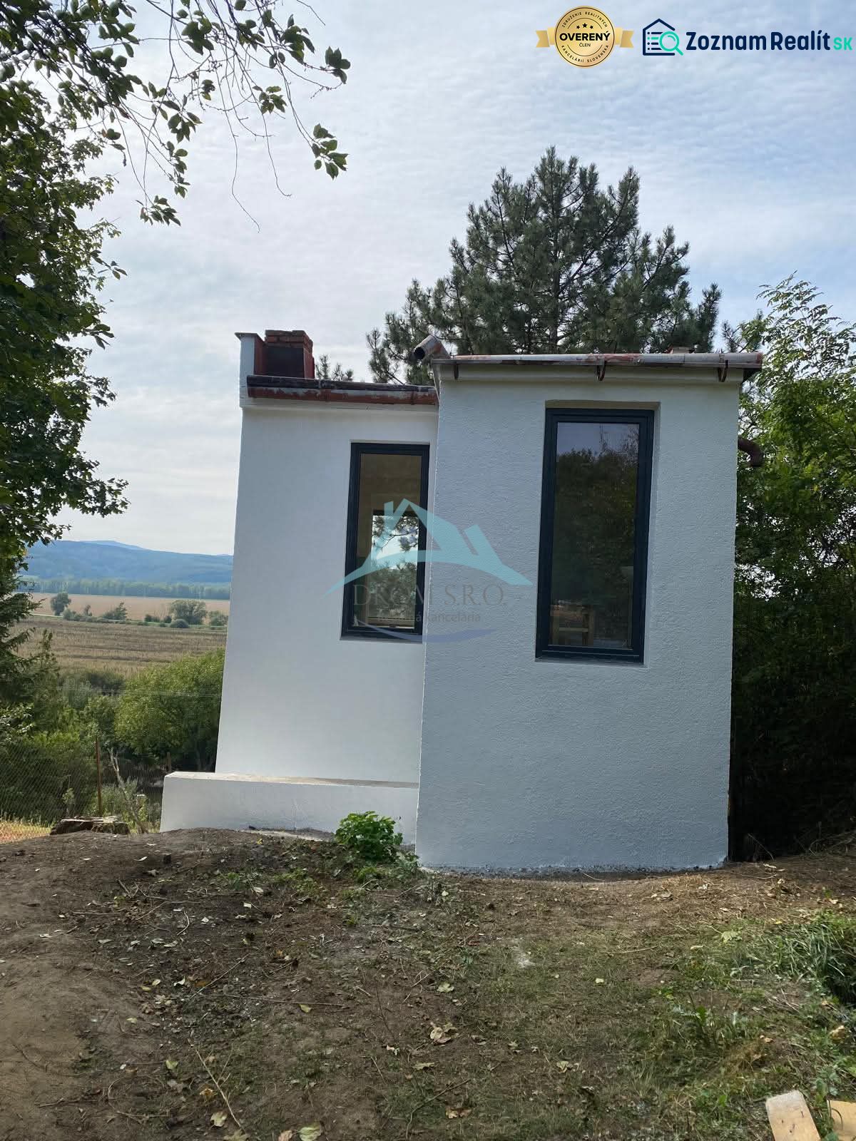 Vaša nová oáza pokoja s investičným potenciálom v Šahách - Malá chata v Šahách, obklopená stromami a krásnou prírodou.