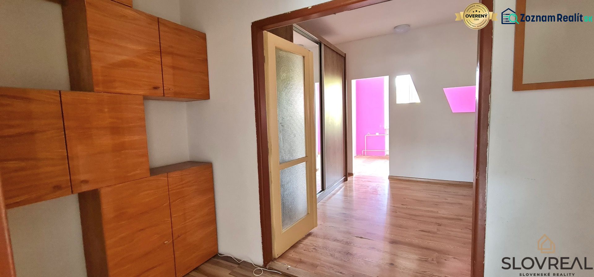 Na predaj 2i byt Levice, 48m2 - Interiér 2-izbového bytu s podlahou s dreveným dekorom a vstavanou skriňou.