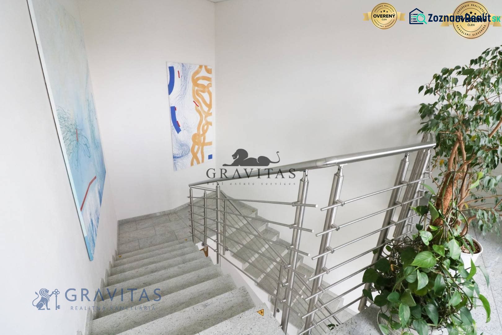 Samostatná kancelária 19,16 m2 - Lamačská cesta - Schodisko v kanceláriách na Lamačskej ceste s umeleckými obrazmi a rastlinou.