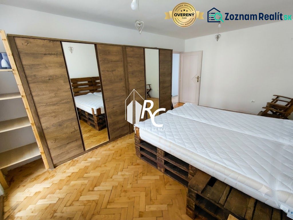 2 izbový byt v CENTRE Martina s veľkou loggiou - Spálňa v 2-izbovom byte s podlahou s dreveným dekorom a priestrannou skriňou.