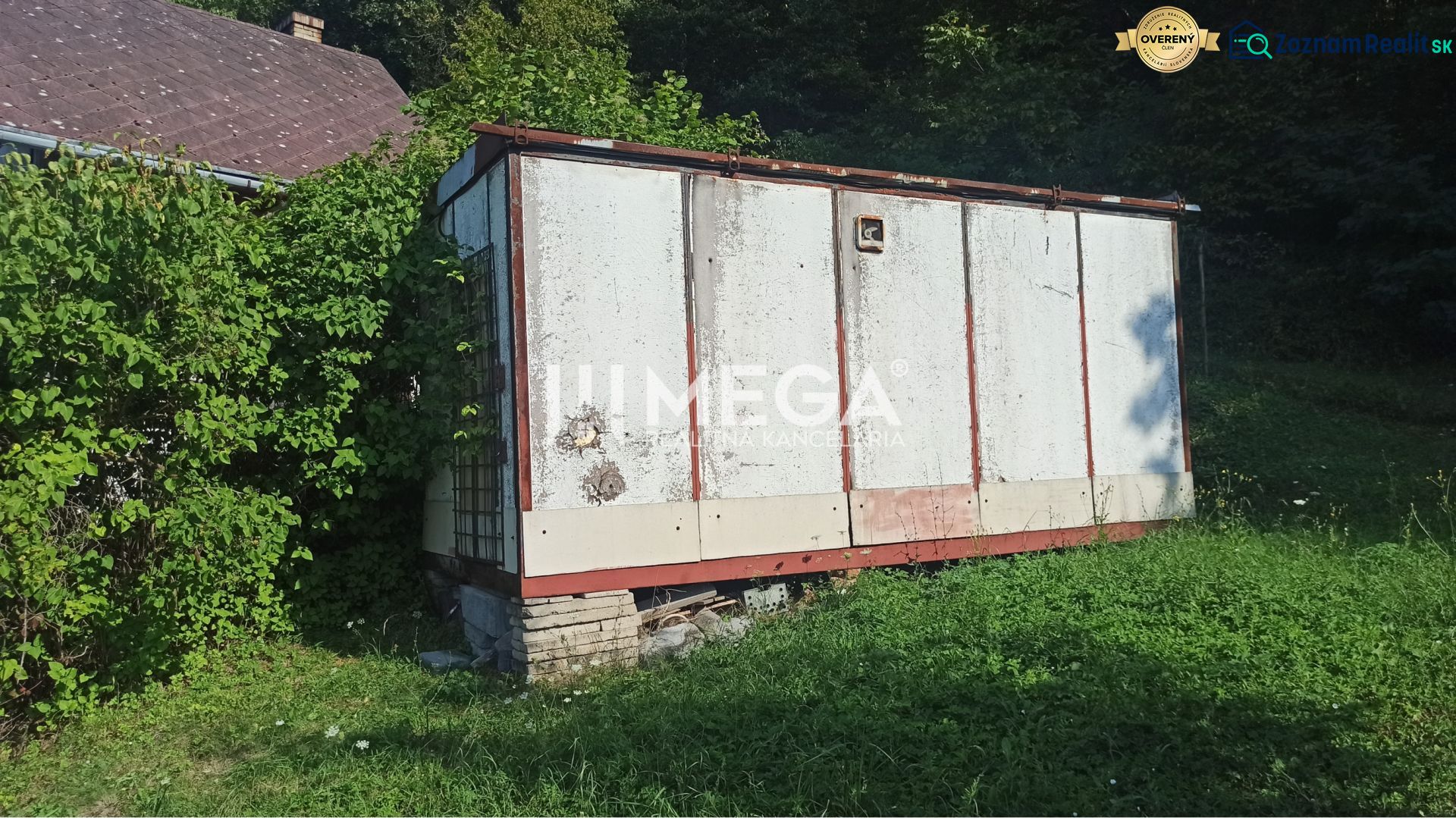 Na predaj pozemok/záhradka v záhradkárskej osade Poniklec Humenné - Starší sklad v záhrade ulice v Humennom, obklopený zeleňou a rastúcou trávou.