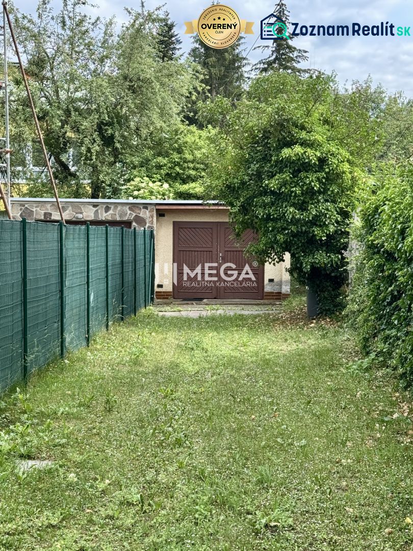 Na predaj garáž s pozemkom na sidl. IIA v meste Humenné - Garáž na ulici Osloboditeľov v Humennom, obklopená zeleňou a plotom.