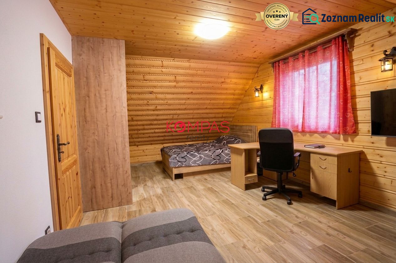 NOVOSTAVBA DOMU V MODERNOM VIDIECKOM ŠTÝLE, OBKLOPENÁ PRÍRODOU A S VEĽ - Izba v rodinnom dome s drevenými stenami, podlahou s dreveným dekorom a pracovným stolom.