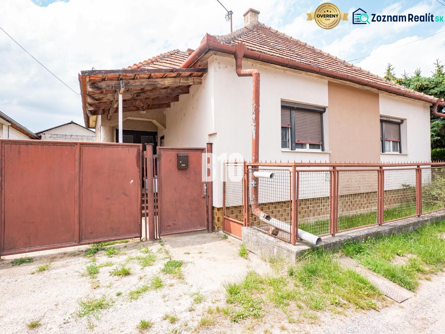 DOM, 1439 m2 pozemkom - Zbehy, Nitra (investičný potenciál) - Rodinný dom v Nitre s plechovým plotom a šikmou strechou.