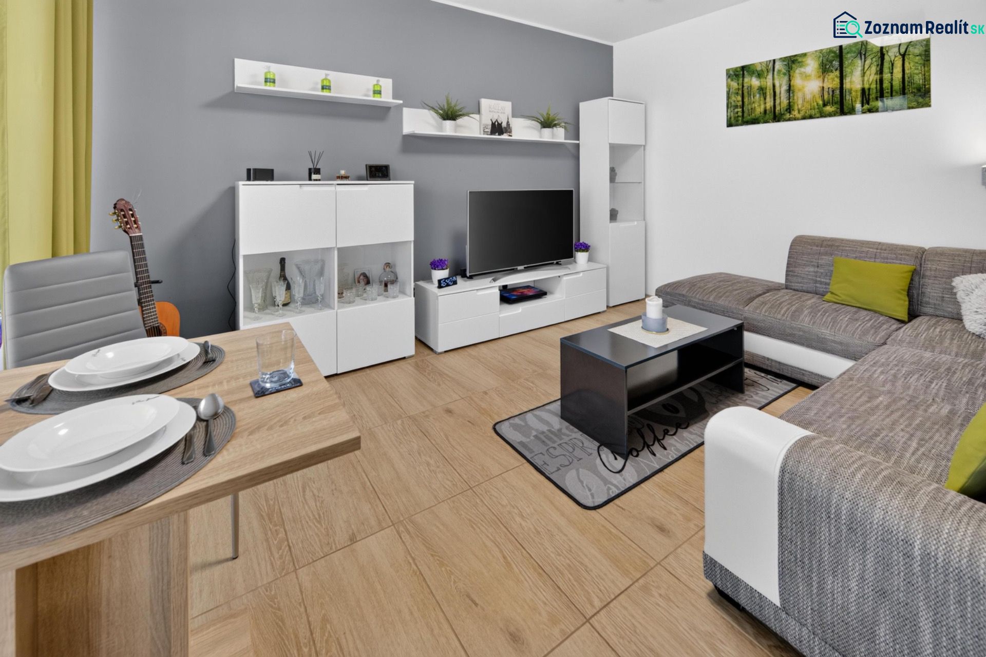 Predaj 2-izbový byt GREEN VILLAGE, loggia, parkovanie, Dunajská Lužná - Obývacia izba v 2-izbovom byte s podlahou s dreveným dekorom a pohodlnou sedačkou.