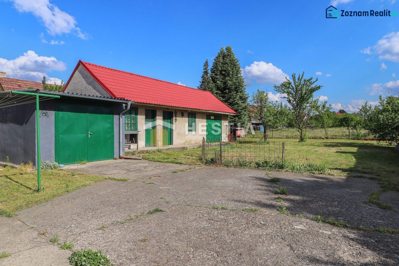 Rodinný dom Borský Mikuláš - Rodinný dom v Borskom Mikuláši s trávnatou záhradou a červenou strechou.