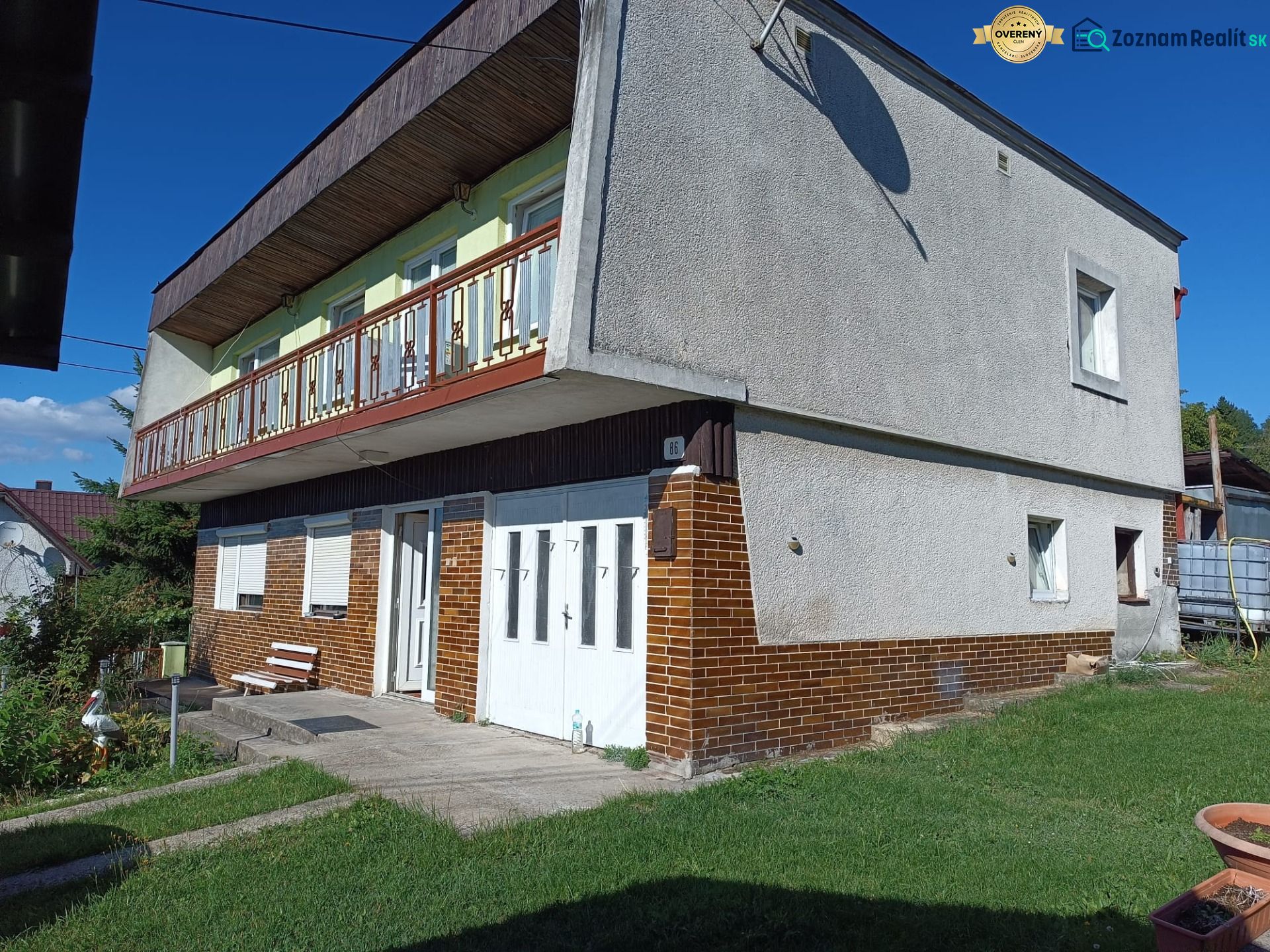 Rodinný dom na predaj – Veľká Lehota (okres Žarnovica) - Rodinný dom vo Veľkej Lehote s balkónom, bielou fasádou a hnedými obkladmi.