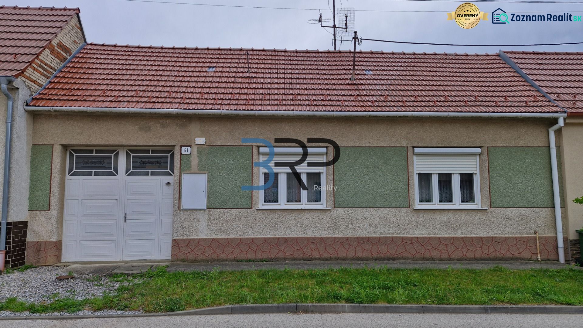 Mokrý Háj - predaj dom - Rodinný dom v Mokrém Háji s červenou strechou a garážovými dverami.