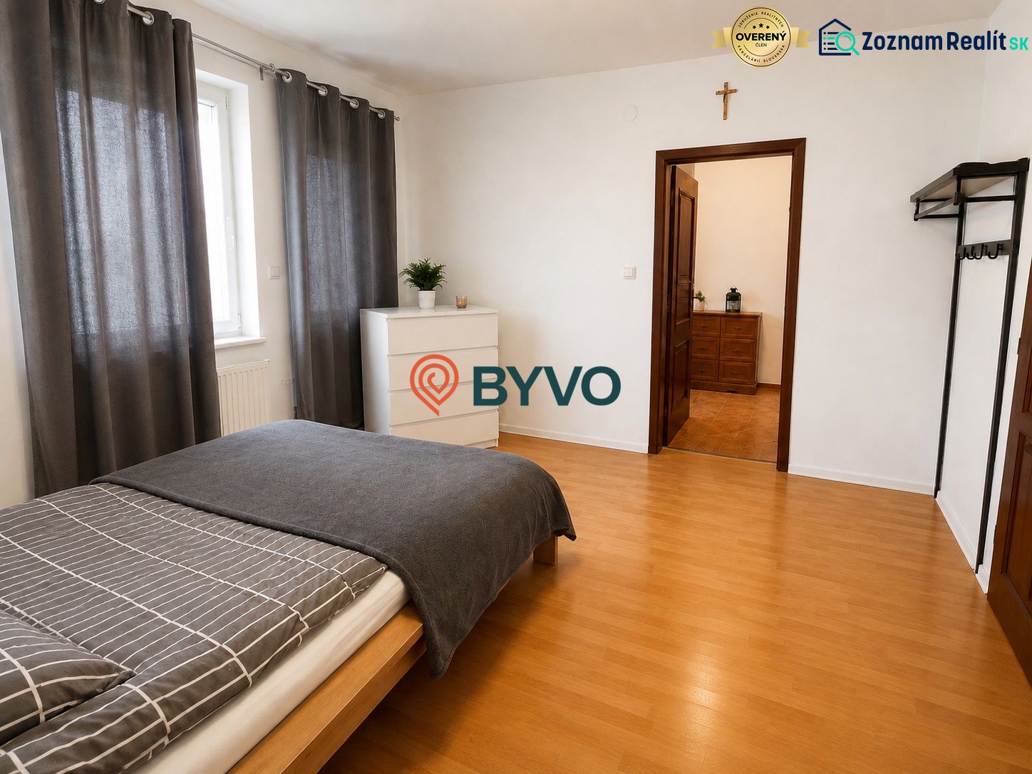 6-izbový rodinný dom v Šamoríne | 201 m² | pozemok 451 m² | - Spálňa v rodinnom dome s posteľou, komodou a podlahou s dreveným dekorom.