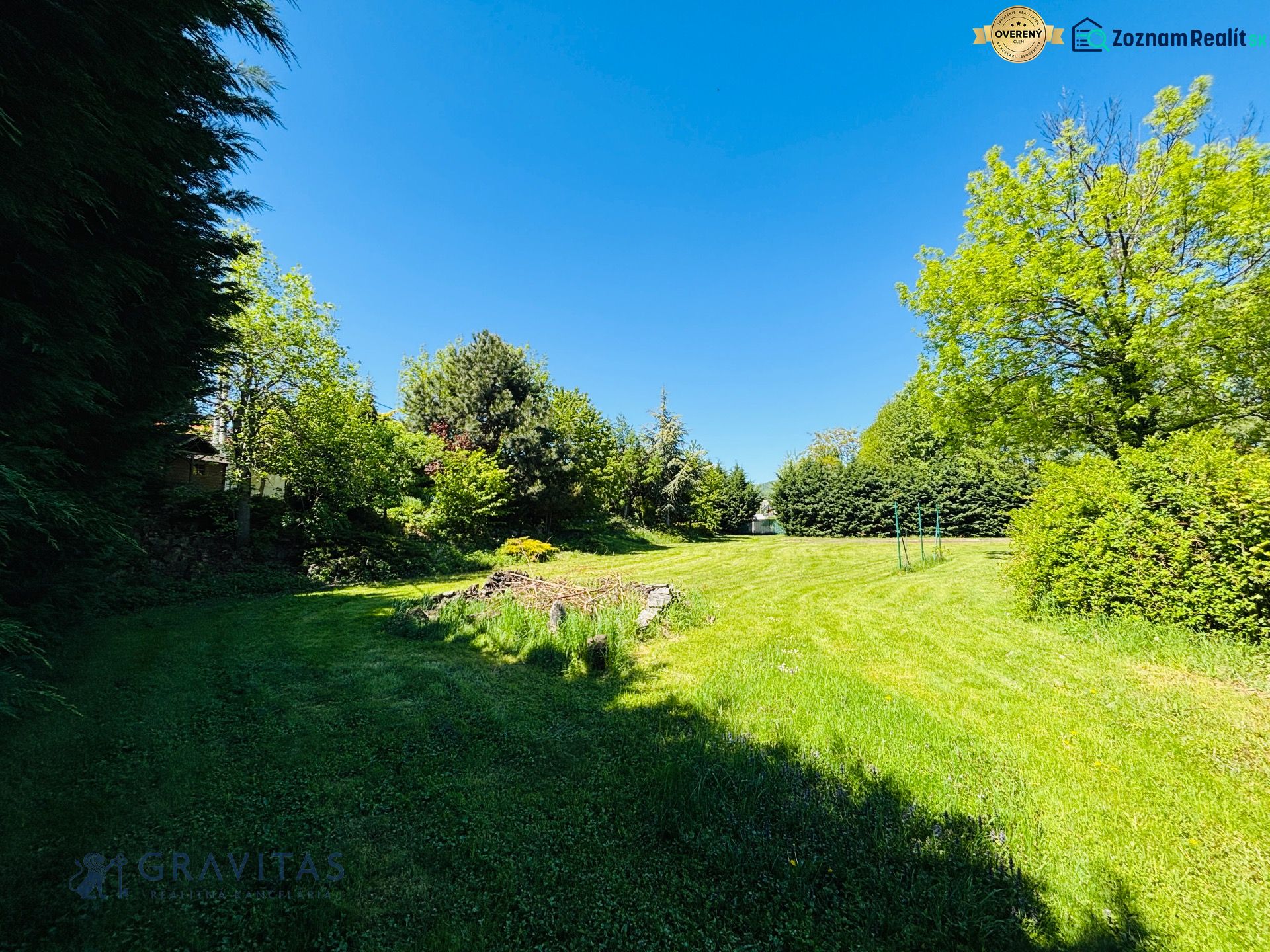 Stavebný Pozemok na Predaj | Limbach | Tichá Krátka ulica - Upravený zelený pozemok na Krátkej ulici v Limbachu s množstvom stromov a kríkov.