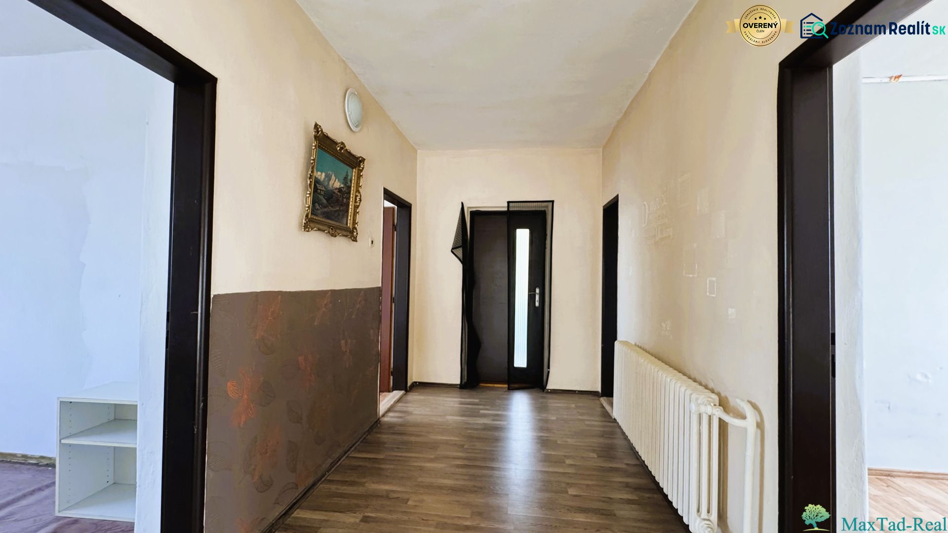 Dve generácie pod jednou strechou, Novosad, rodinný dom, 99.000€ - Chodba v rodinnom dome s podlahou s dreveným dekorom a obrazom na stene.