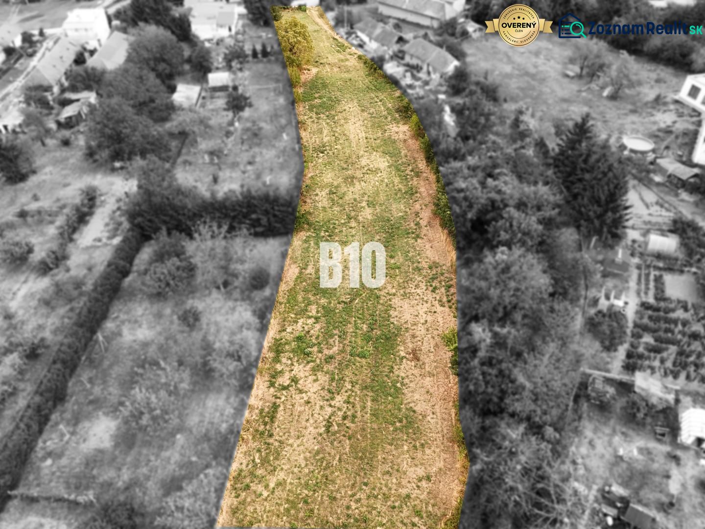 Na predaj pozemok v Kolíňanoch – 2 700 m² - Pozemky - bývanie Kolíňany: Dlhý pozemok so zelenou trávou, lemovaný stromami a stavbami.