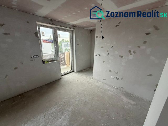 Ponúkame na predaj Rodinný dom v Rovinke na Platanovej ulici - Izba v rodinnom dome počas rekonštrukcie, s betónovou podlahou a veľkým oknom na stenu.