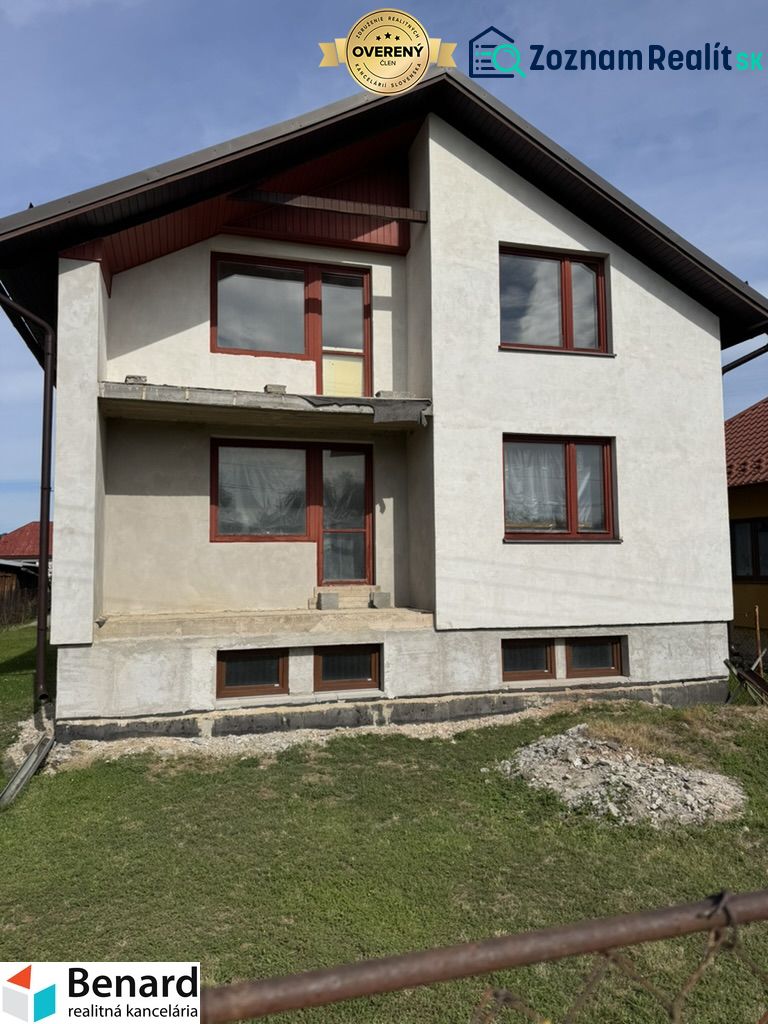 Rozostavaný rodinný dom Plavnica - Rodinný dom v Plavnici s jednoduchou fasádou a novými oknami, s trávnatým pozemkom.