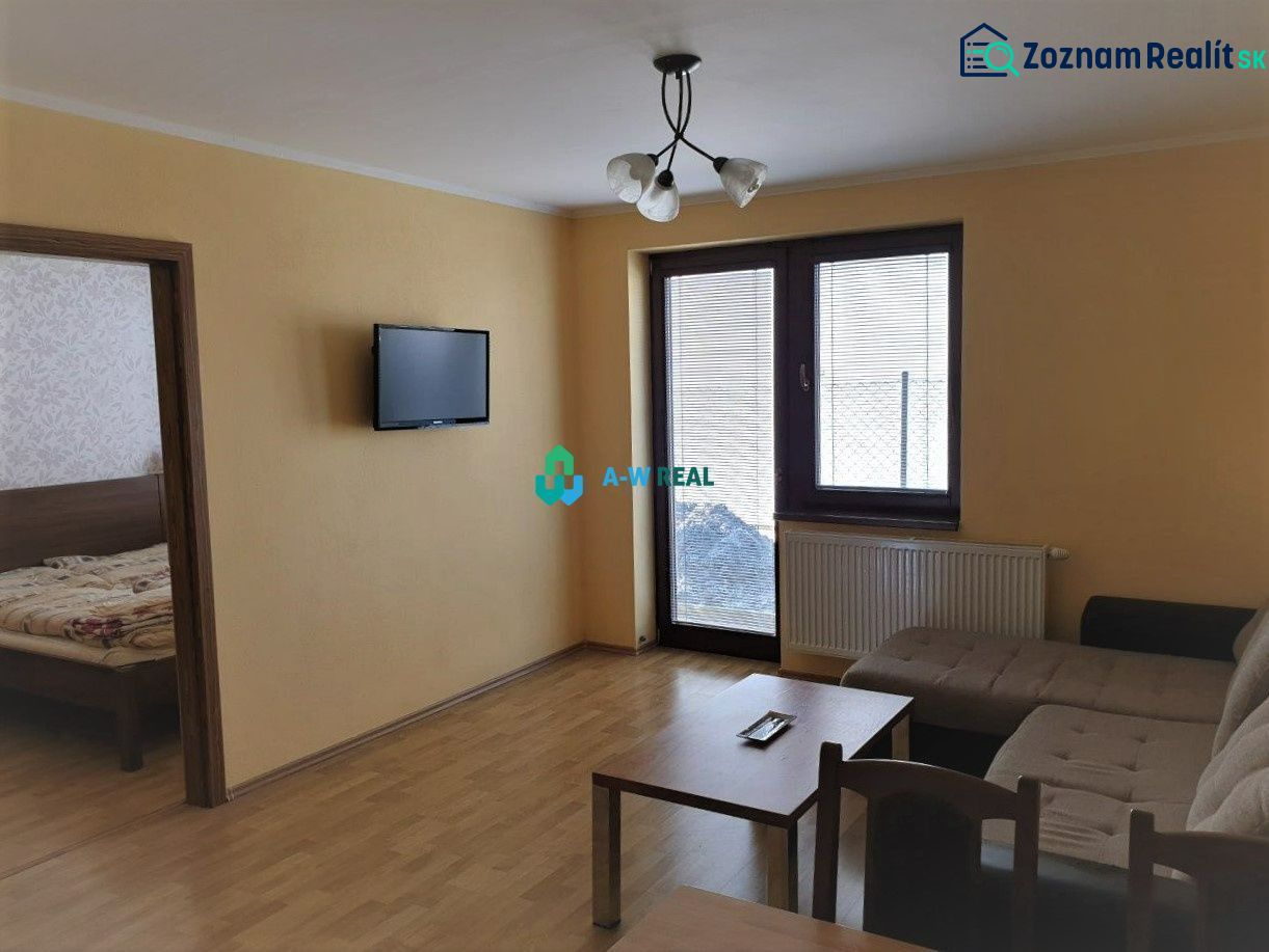 Apartmánový dom na predaj blízko termálneho kúpaliska - Obývacia miestnosť s pohovkou, televízorom a podlahou s dreveným dekorom, Hotely a penzióny.