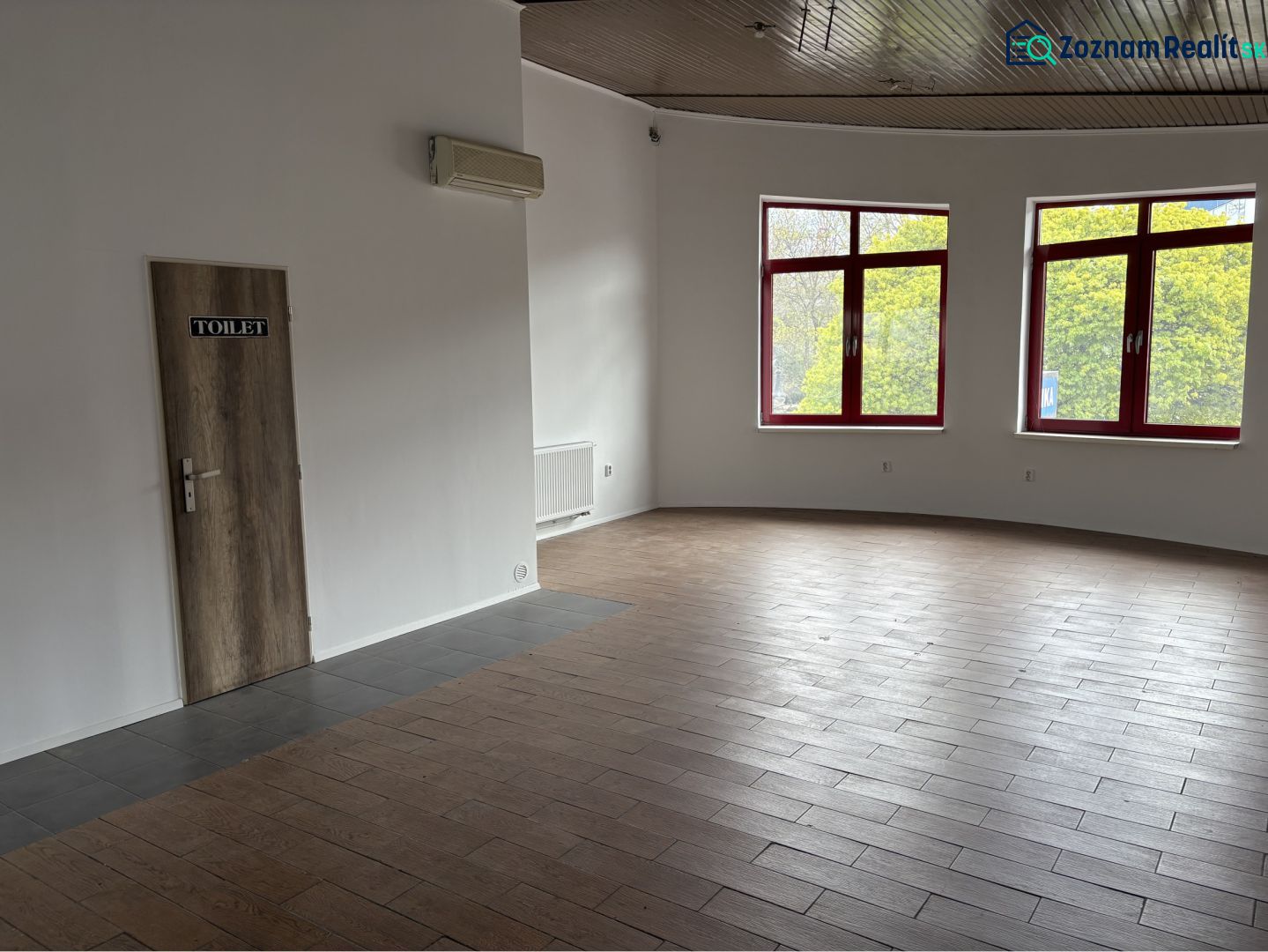 Prenájom nebytového priestoru na podnikateľské účely v CENTRE Dunajske - Interiér budovy s dverami na toalety a podlahou s dreveným dekorom.