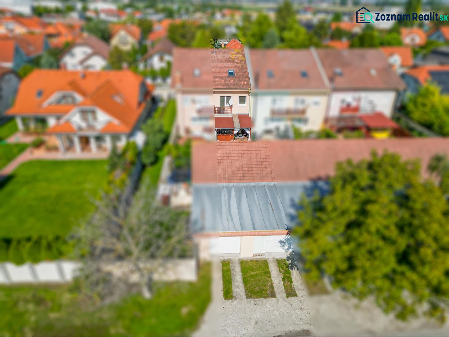 -Na predaj 5 izbový poschodový rodinný dom s 2 garážou v Dunajskej Str - Rodinný dom v Dunajskej Strede s červenou škridlovou strechou a záhradou.