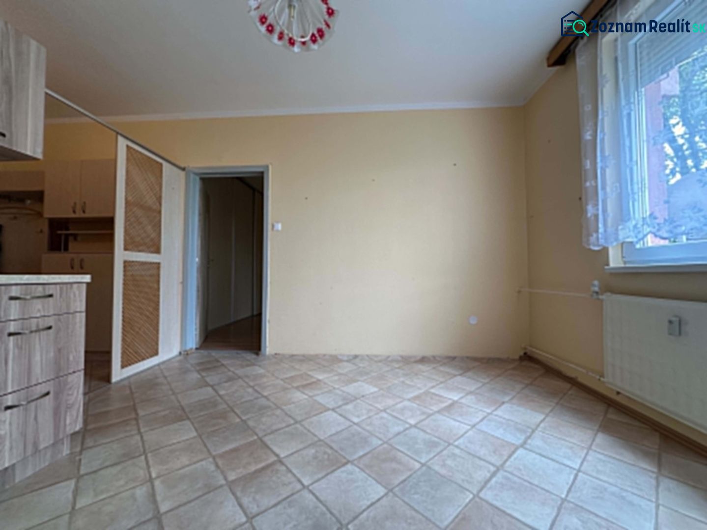REZERVOVANÉ   NOVÁ CENA !!!!  108000,-EUR  NA PREDAJ EXKLUZÍVNE  : 1  - Interiér 1-izbového bytu s béžovou stenou a dlaždicovou podlahou.