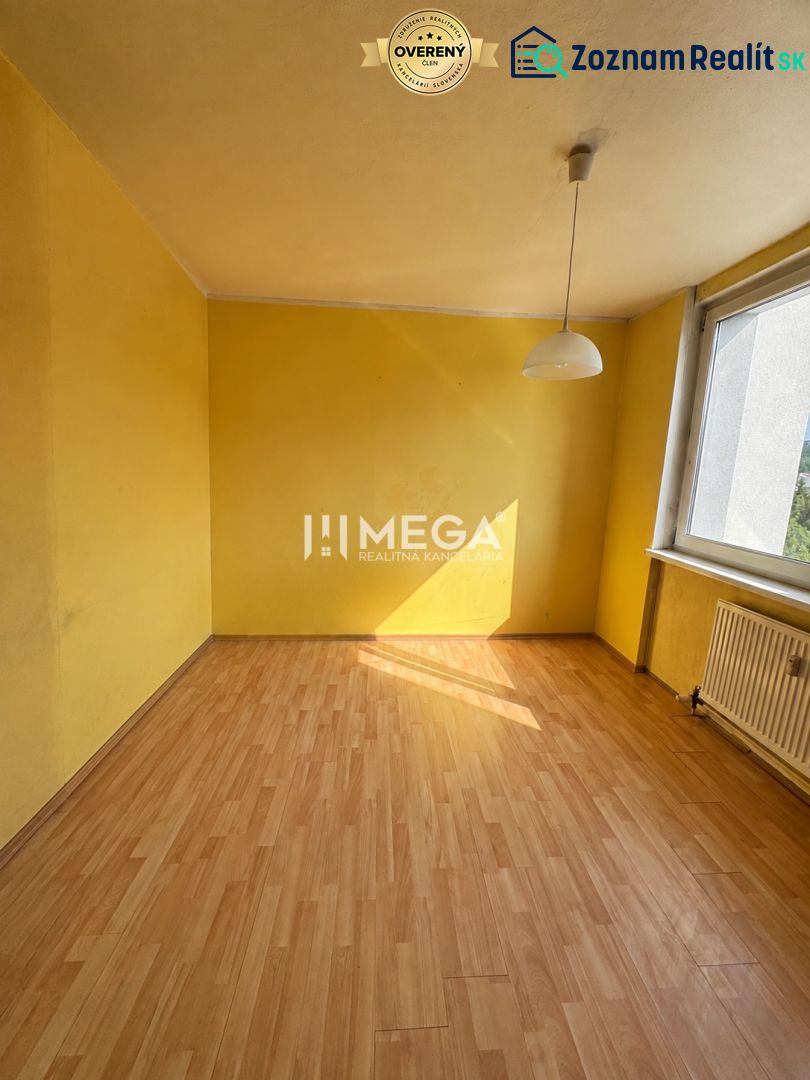 Na predaj 3 izbový byt s balkónom na Sidl.III v Humennom - Žltá miestnosť s veľkým oknom a podlahou s dreveným dekorom v 3-izbovom byte.