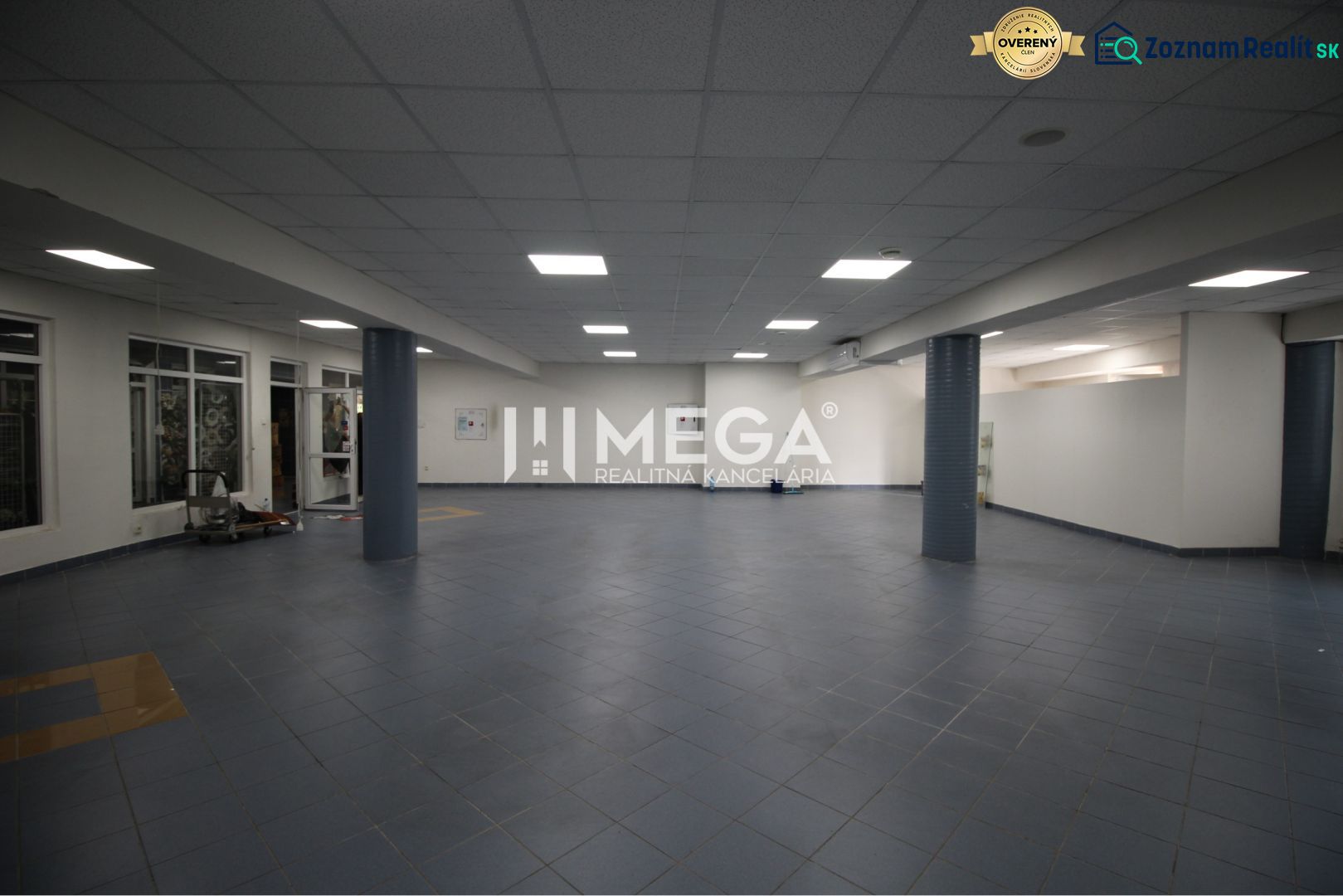 Na prenájom - priestor 185 m2 v centre mesta Humenné - Priestranné obchodné priestory s modrou dlažbou a stĺpmi ponúkajú rôzne možnosti využitia.