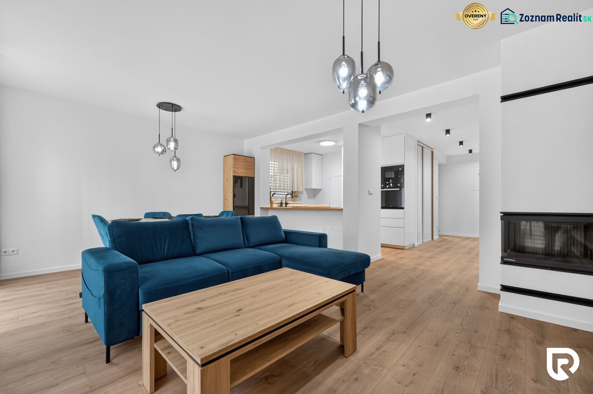 4i RD s pozemkom 170 m2  | ul. Vážska | Trenčín - Obývacia izba v rodinnom dome s modrou sedačkou a podlahou s dreveným dekorom.