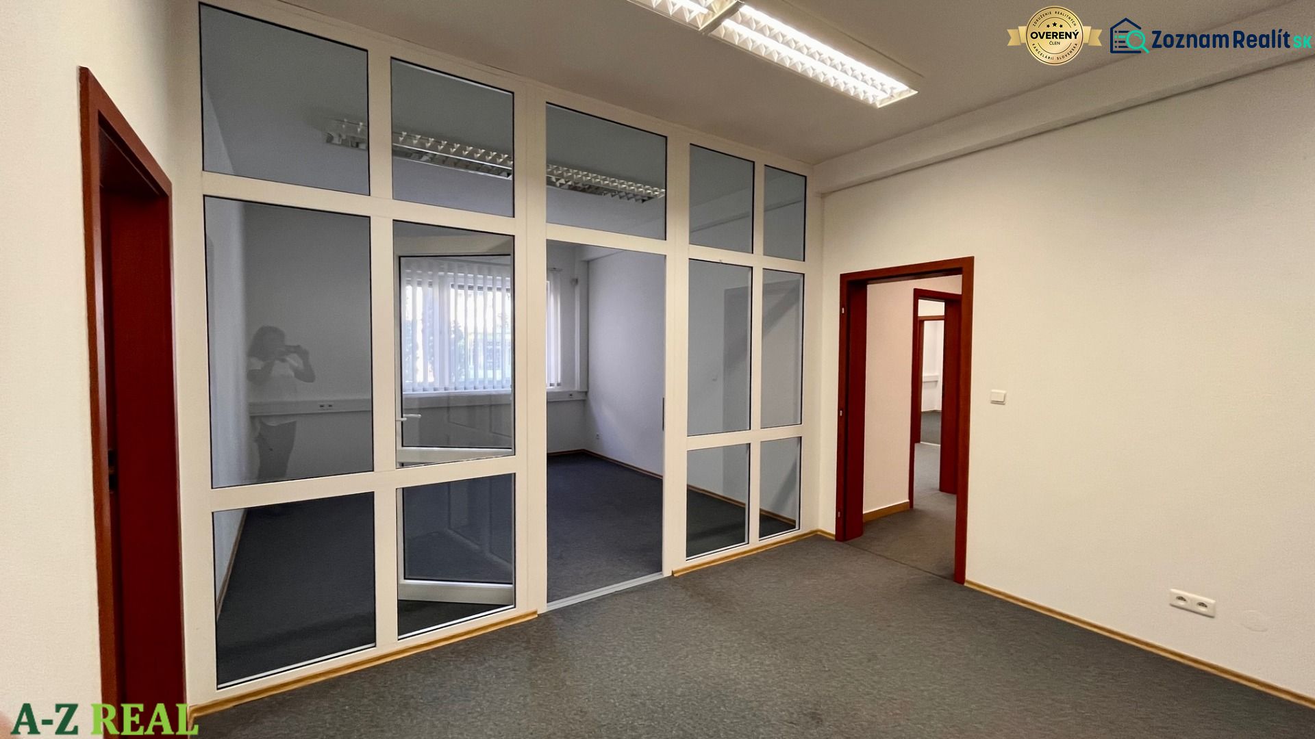 Prenájom kancelárskych priestorov Ružinov, 100 m2,  parking - Kancelárie s presklenými stenami a tmavým kobercom na podlahe.