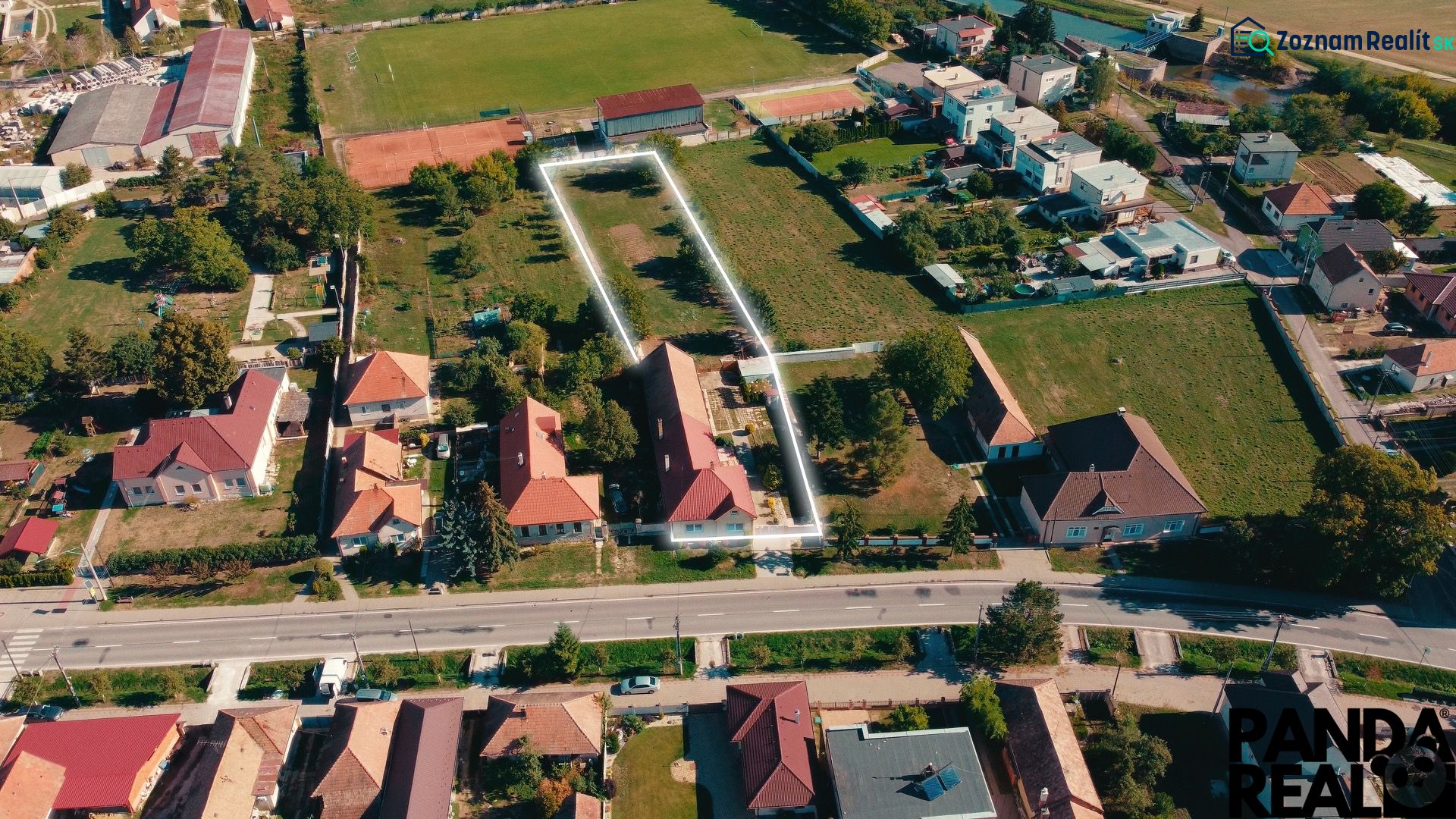 5 IZB. RODINNÝ DOM S ROZĽAHLÝM POZEMKOM 2 751 m² – NADLICE - Letecký pohľad na rodinné domy a záhrady v Nadliciach, obklopené zeleňou a cestami.