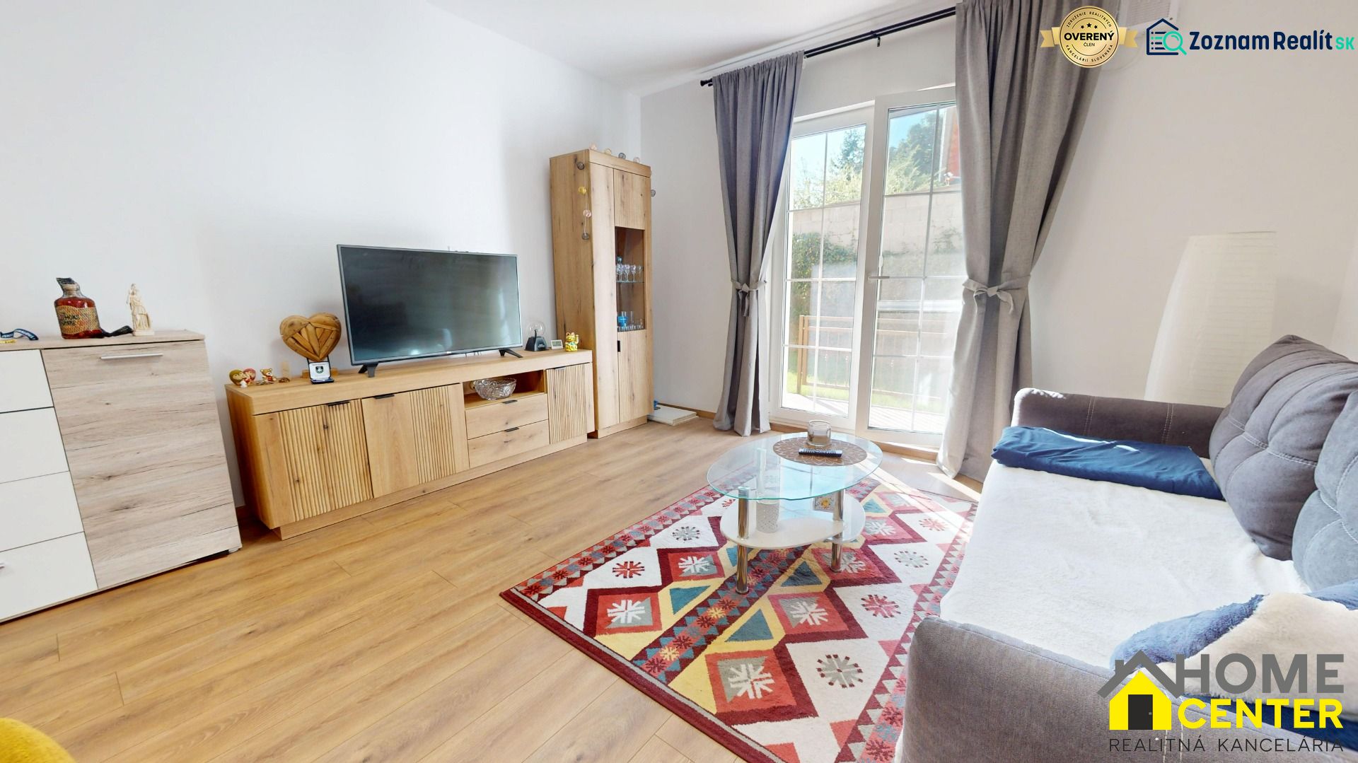 PRENÁJOM 2 izbový, zariadený byt v Danube residencia - REZERVOVANÉ - Obývacia izba v 2-izbovom byte s podlahou s dreveným dekorom a farebným kobercom.