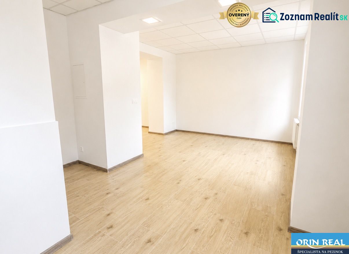 Na prenájom obchodný priestor v centre Pezinka 100m2 - Obchodné priestory s podlahou s dreveným dekorom a bielymi stenami.