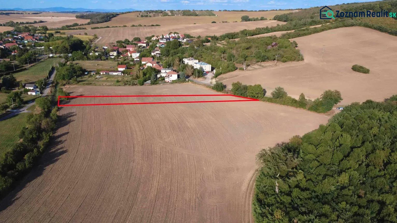 Podhájska - 2.084 m2 POZEMOK na okraji obce - Poľnohospodárske a lesné pozemky v Podhájskej, s výhľadom na okolité polia a zeleň.