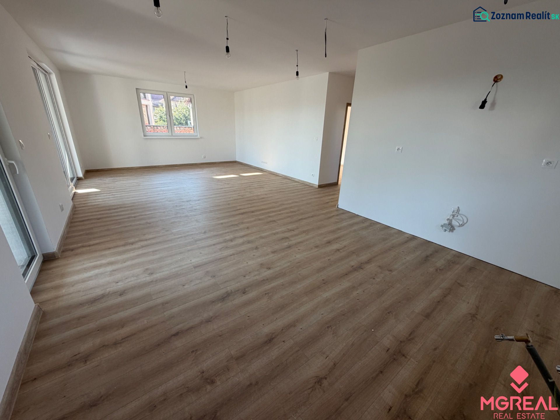 Novostavba rodinný dom Preseľany  - Interiér rodinného domu s podlahou s dreveným dekorom a bielymi stenami.