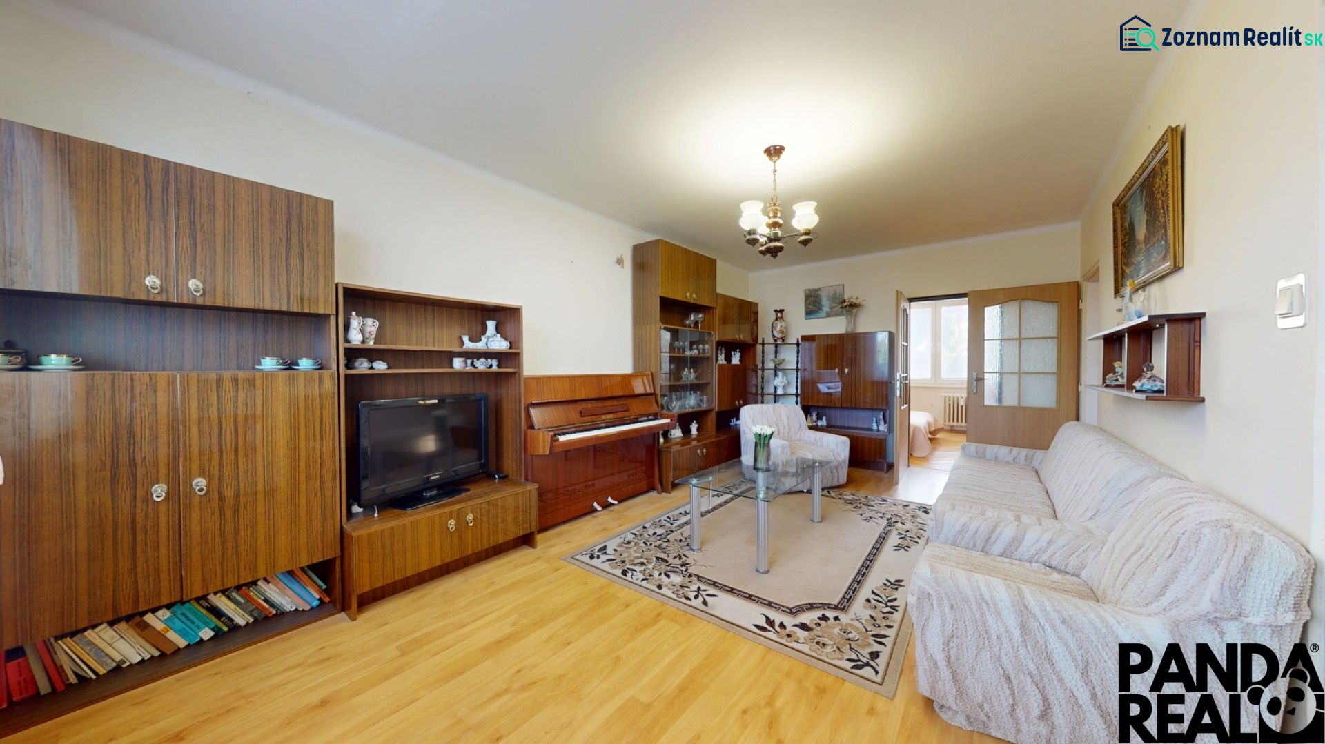 3.izbový byt so záhradou /420 m²/ a chatkou BOŠANY - Obývačka 3-izbového bytu s nábytkom, klavírom a podlahou s dreveným dekorom.