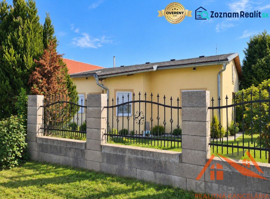 Na predaj rodinný dom s krásnym rozsiahlym pozemkom Martovce! - Rodinný dom v Martovciach so záhradou obklopený zelenými stromami a plotom.