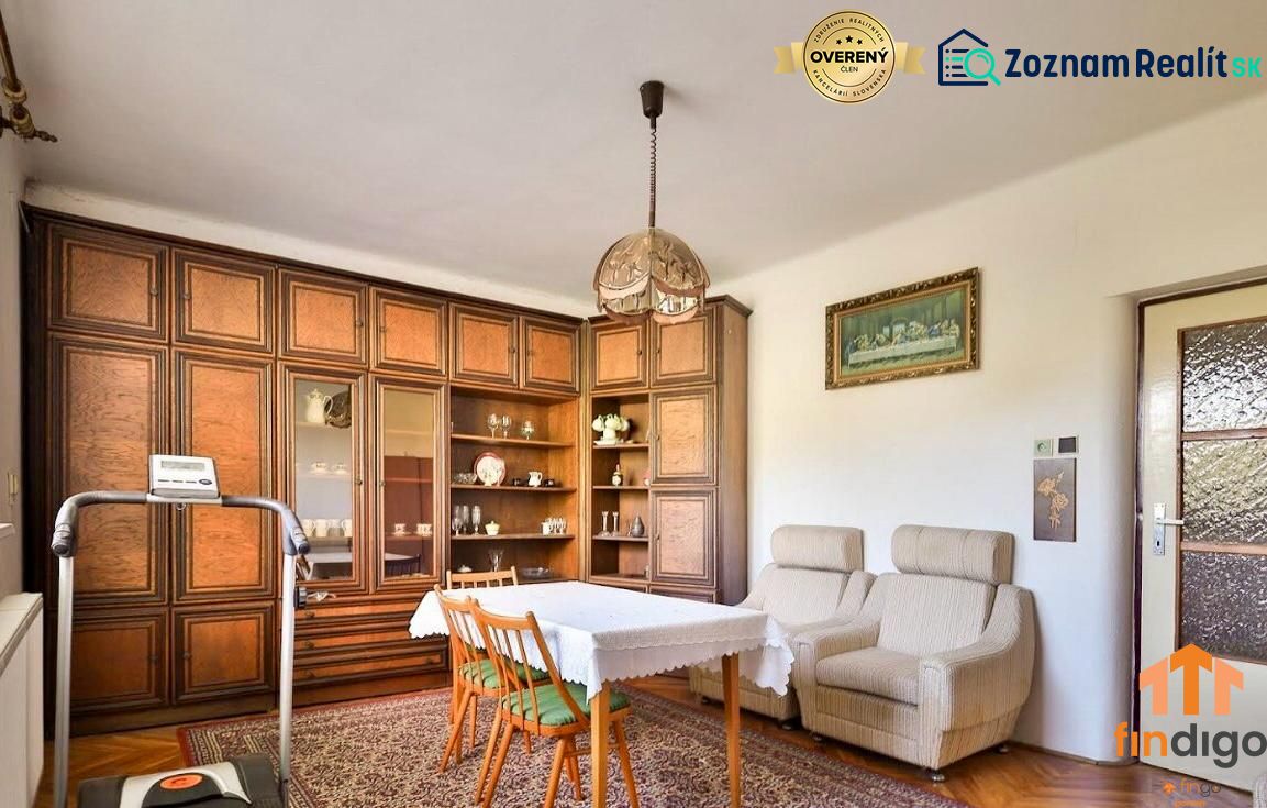 PREDAJ - Rodinný dom s priestranným pozemkom 2266 m² - Veľký Kýr - Obývacia izba s podlahou s dreveným dekorom v rodinnom dome, útulné kreslá a skriňová zostava.