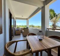 APARTMÁN NA PREDAJ V PAJE, ZANZIBAR - Na obrázku vidno terasu s dreveným nábytkom, palmy na ulici Paje a garsónka.