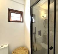 APARTMÁN NA PREDAJ V PAJE, ZANZIBAR - Kúpeľňa so sprchovým kútom, oknom, toaletou a pleteným košom na ulici Paje.