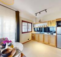 APARTMÁN NA PREDAJ V PAJE, ZANZIBAR - Kuchyňa s drevenou skrinkou, jedálenským stolom a 1-izbový byt so svetlým interiérom.