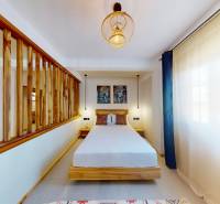 APARTMÁN NA PREDAJ V PAJE, ZANZIBAR - Na obrázku je útulná spálňa s dreveným rámom, osvetlená lustrami a 1-izbový byt.