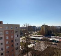 Kompletne zariadený 2-izbový byt (pôvodne 3-izb.) – Vodná ul. Komárno - Pohľad z 3-izbového bytu, na ulici Vodná, na sídlisko s parkoviskom a stromami.